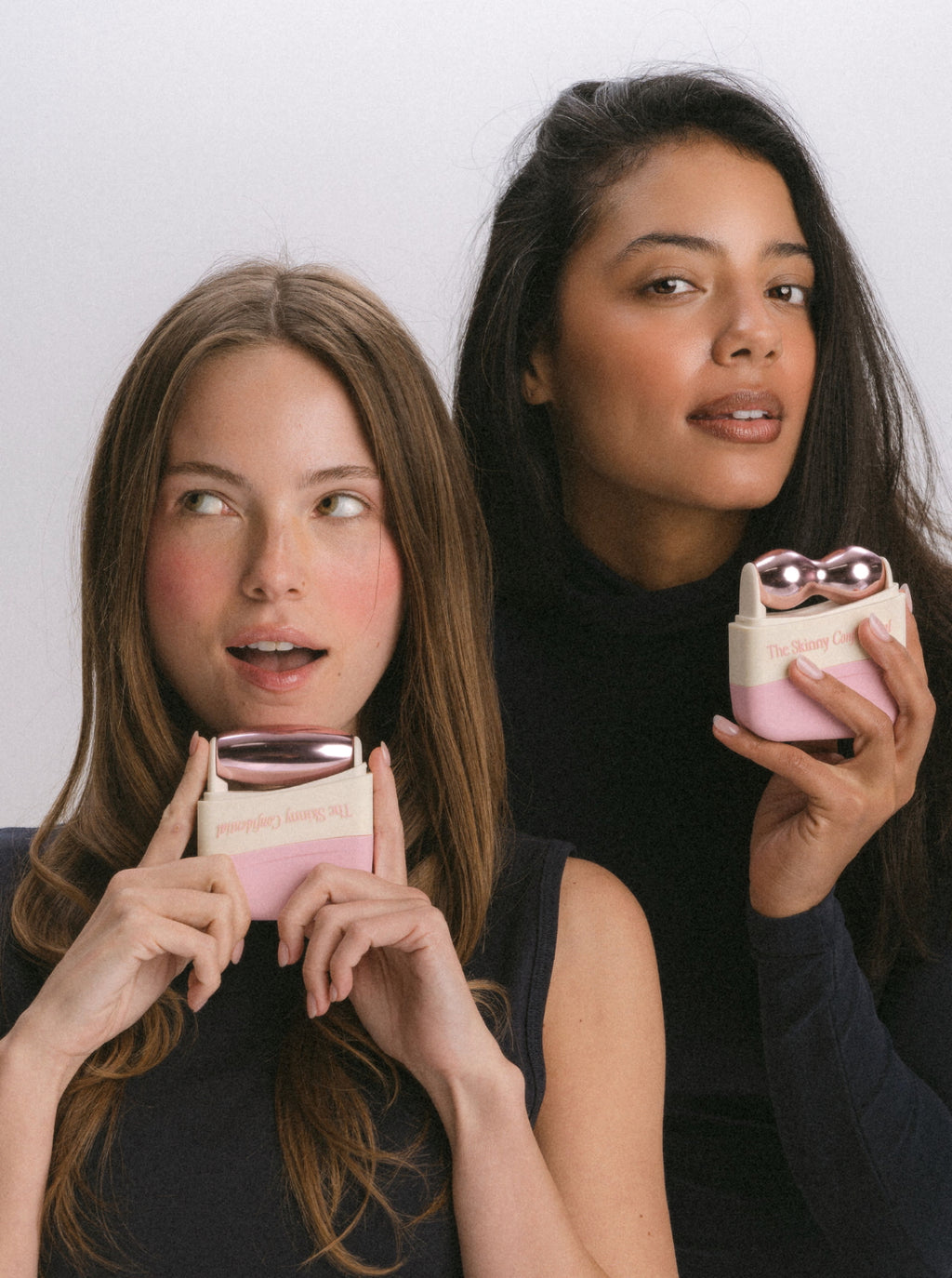Two women holding beauty face massager skincare products