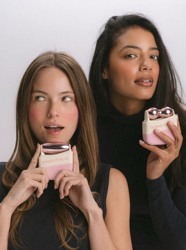 Two women holding beauty face massager skincare products