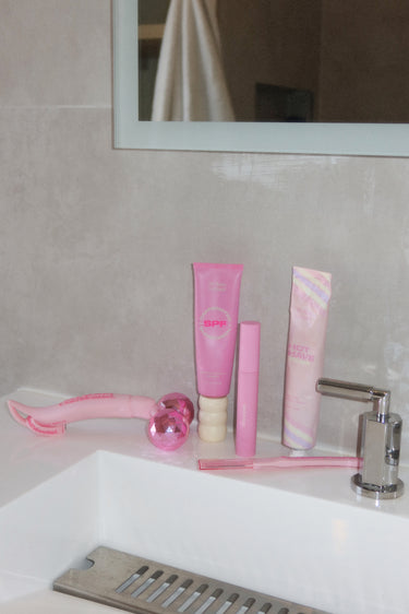 pink skincare products on bathroom counter